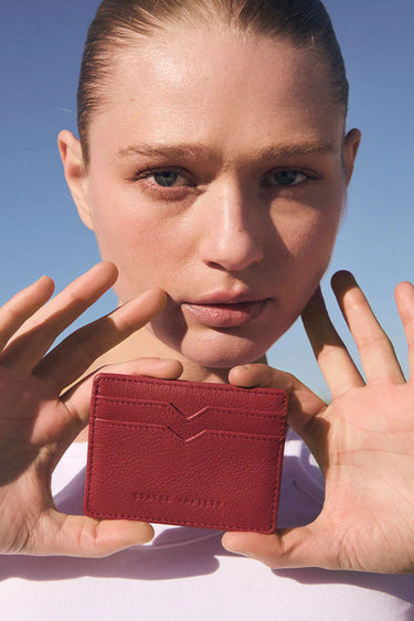 Model holding red card wallet 