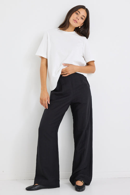 model wears a black linen wide leg pant and a white t-shirt