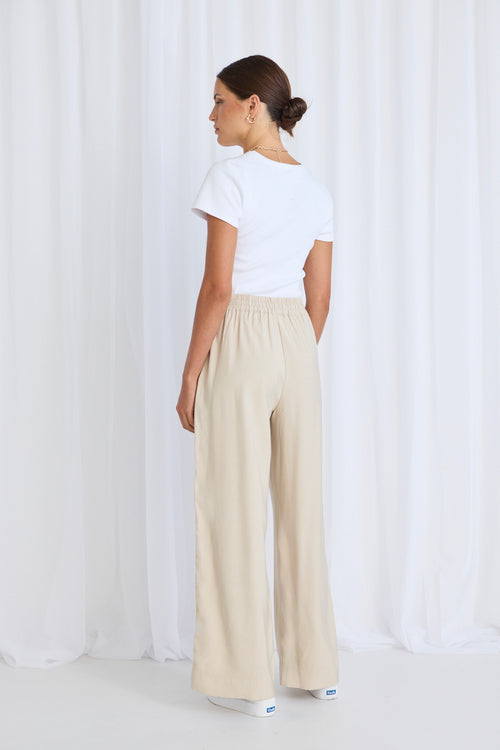 model wears beige pants and a white tee
