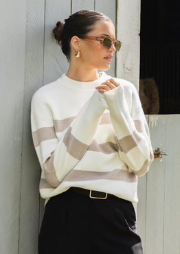 model wears a stripe knit with black pants