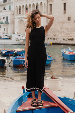 model wears black rib knit maxi dress outside on a boat