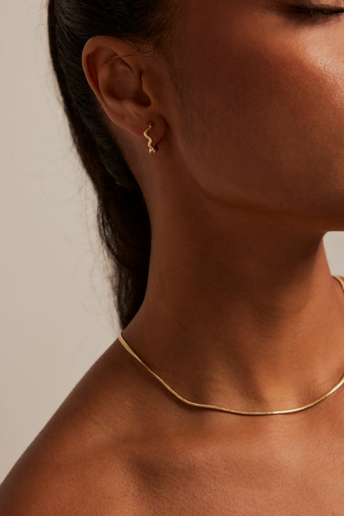 Model wears wavey hoop gold earring