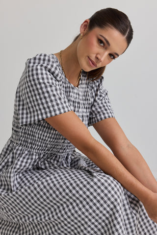 model wears a black gingham midi dress