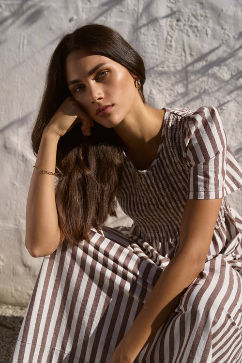 model wears choc stripe dress