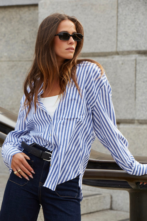 model wears a blue stripe shirt with a dark blue jeans
